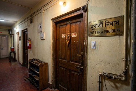 Apartment entrance at dusk with the main door, doorbell and a small camera